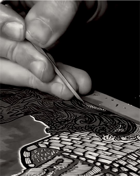 Hands cutting an image into a lino block with a gouge